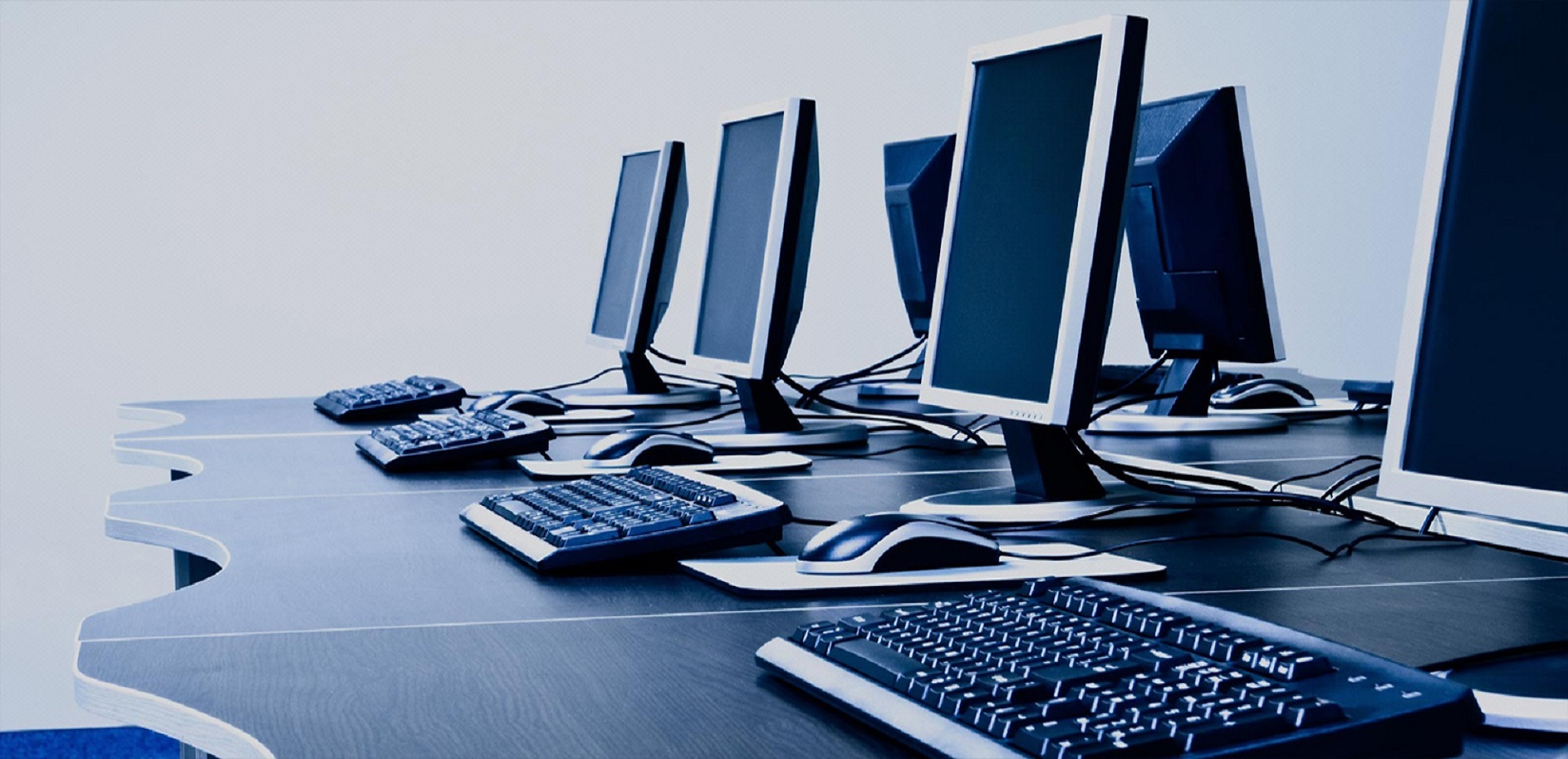 Efficient Managed IT Services: Four Modern Desktop Setups with Keyboards and Mice on Table